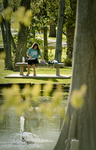 Student studying near the pond