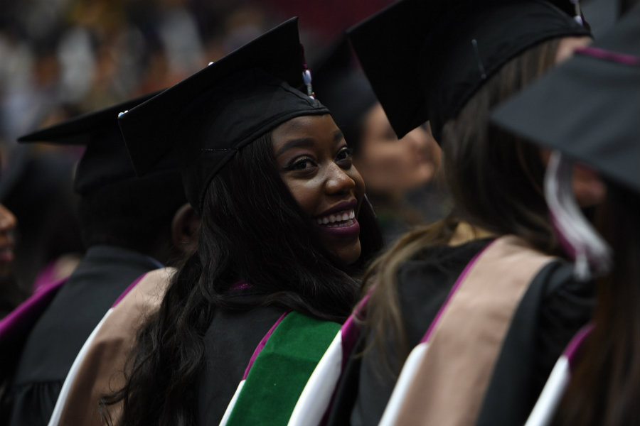 A graduate smiling at her commencement ceremony.