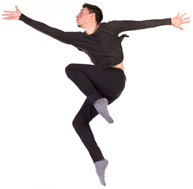 Male student dressed in black leaps into the air