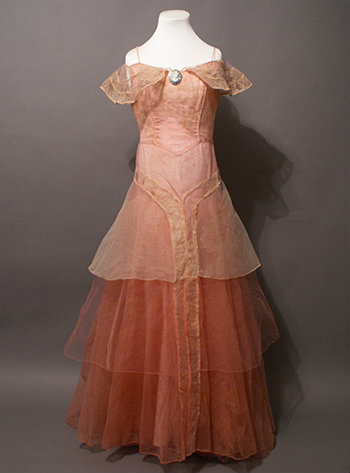 The full dress is shown. It begins with a light pink that transitions to red with layers of chiffon.