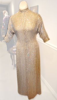 A sequin-covered silk chiffon gown with a mandarin collar and fitted three-quarter length sleeves.