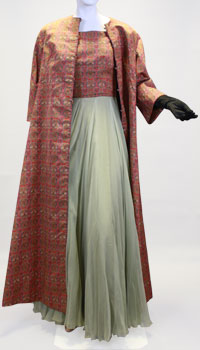 A gown with a light green silk skirt and red plaid top with a matching red plaid long coat. 