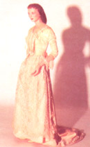 A long, light pink dress is shown with mid-length sleeves and lace trim.