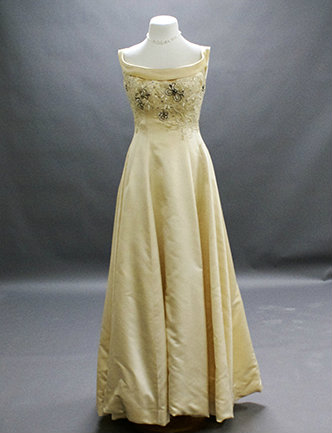 A white silk satin gown with appliquéd beading of crystals, pearls and rhinestones.