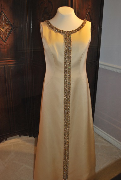 The full sleeveless cream silk gown is shown with jeweled embellishments down the front and neckline