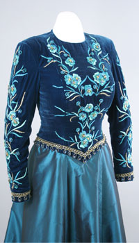 A teal skirt and a navy blue bodice that is decorated with a floral motif embroidery.