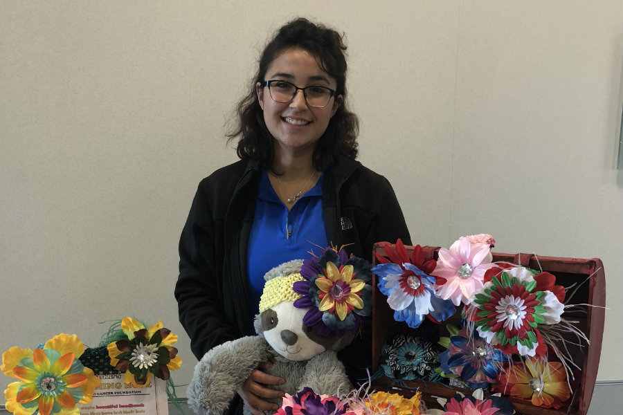 Meagan Ortega smiling in front of a table of crafts for Brooke's Blossoms.