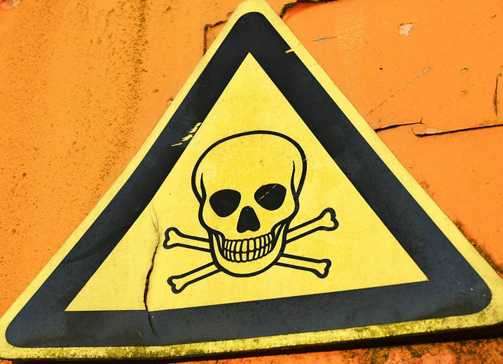 Yellow triangle warning sign with skull and cross bones.