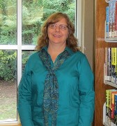 A photo of Sue Ridnour. She has blonde hair and is wearing a teal blouse.
